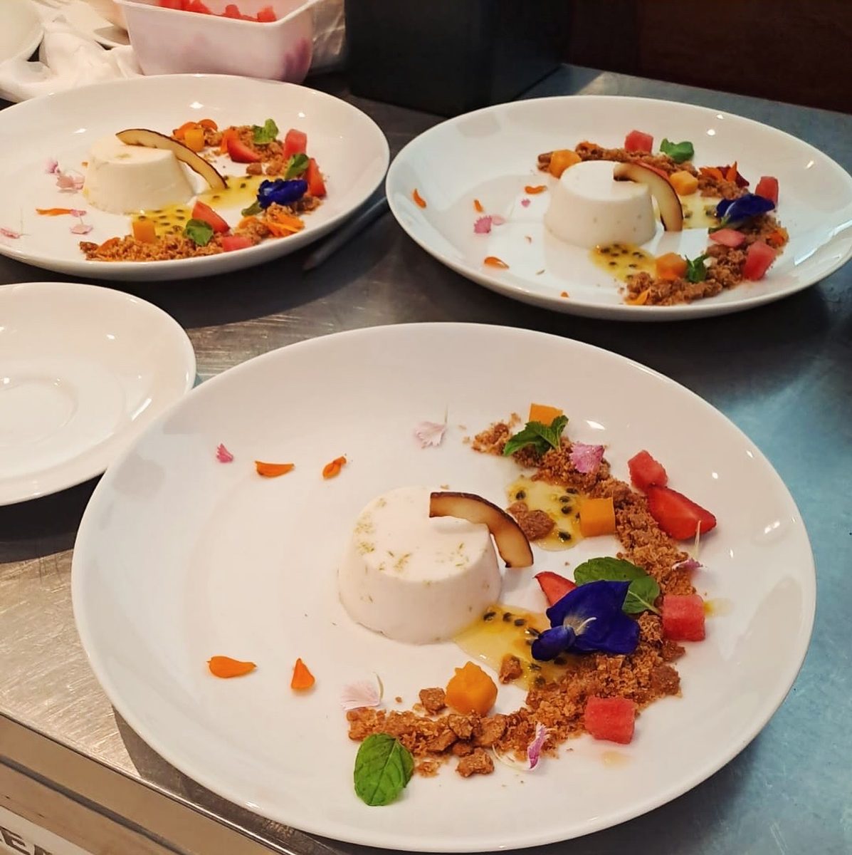 Chefs plating coconut panna cotta at the pass at Taprobane House