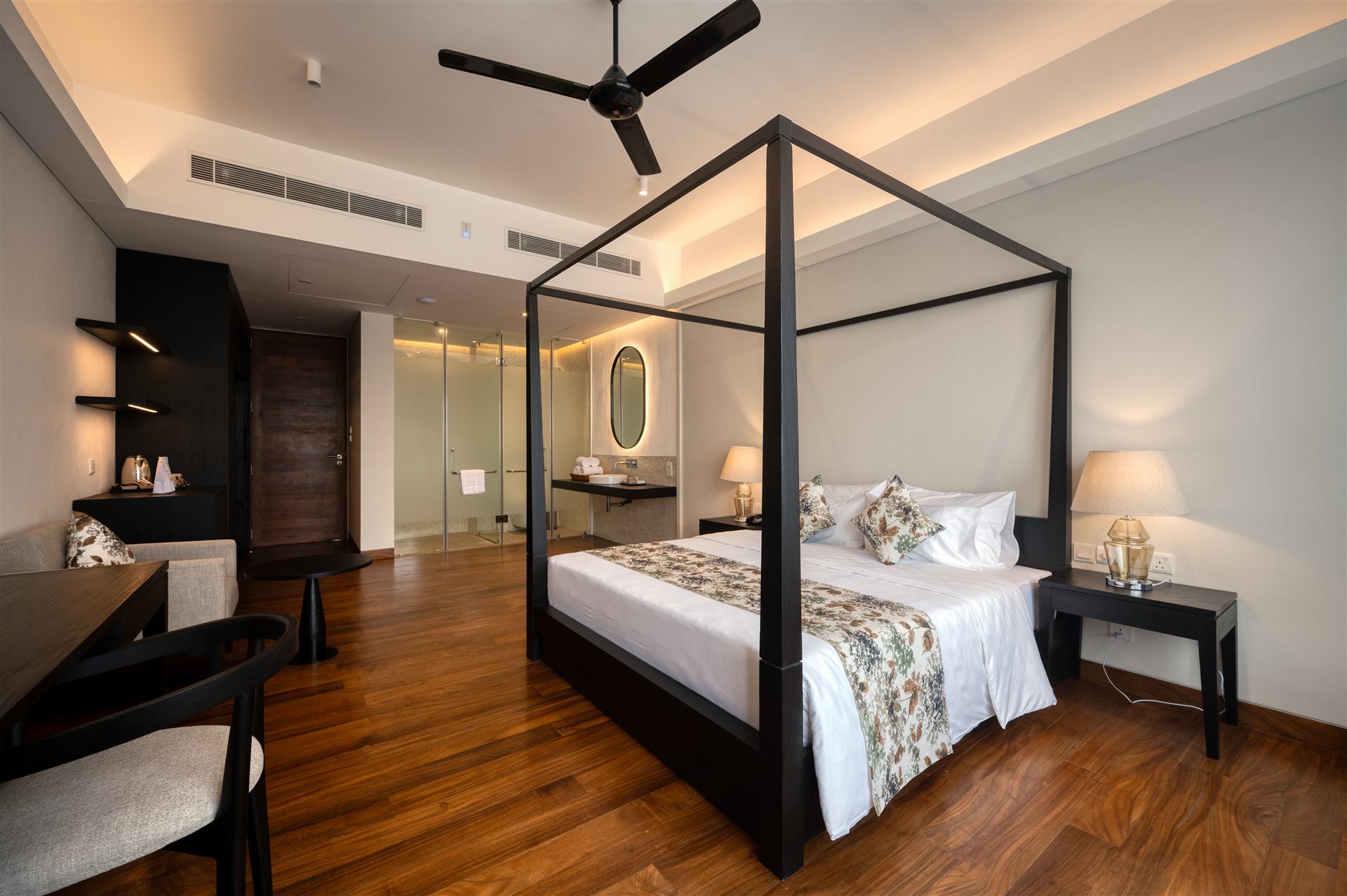 Four-poster bed with bedside lamps and dressing area
