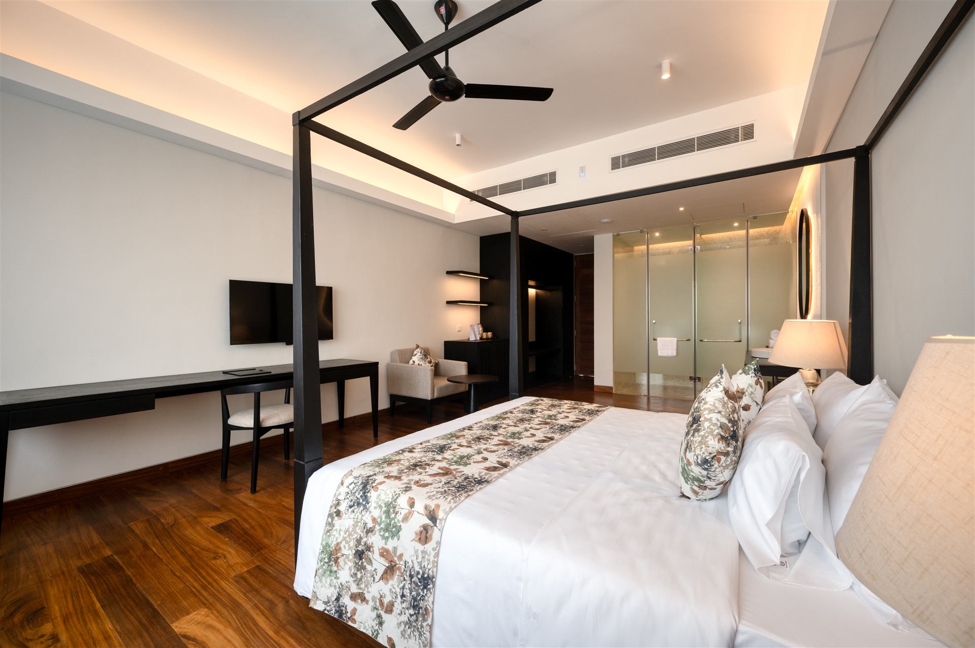 Guest room with four-poster bed, timber floors and work desk
