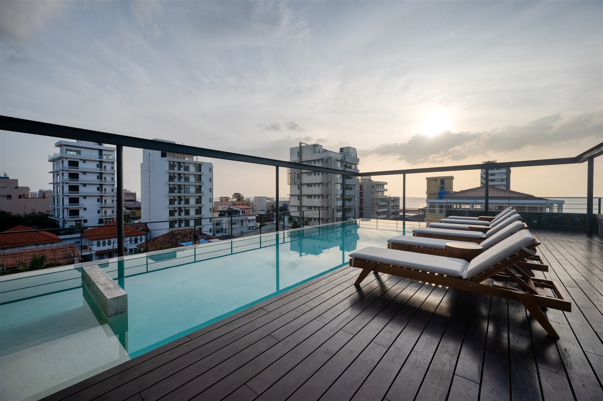 Infinity-edge rooftop pool at sunset over Colombo